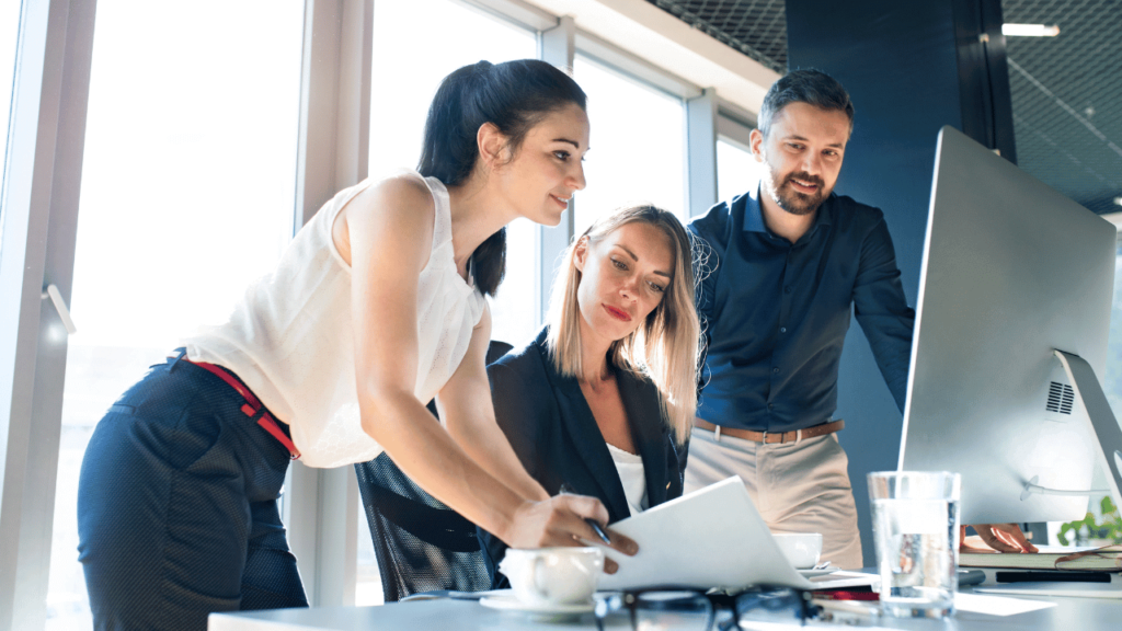 Equipe de 3 pessoas analisando KPIs de SEO.